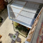 Waterproof glass-enclosed courtyard lounge with integrated lighting